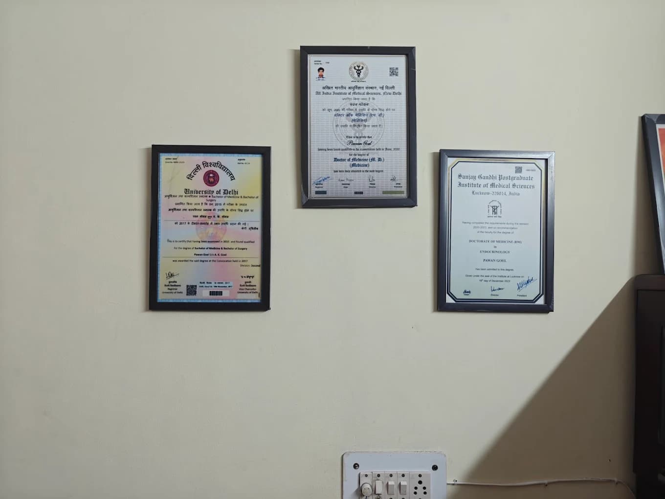 Dr. Pawan Goel's MBBS, MD and DM degree certificates displayed in the clinic